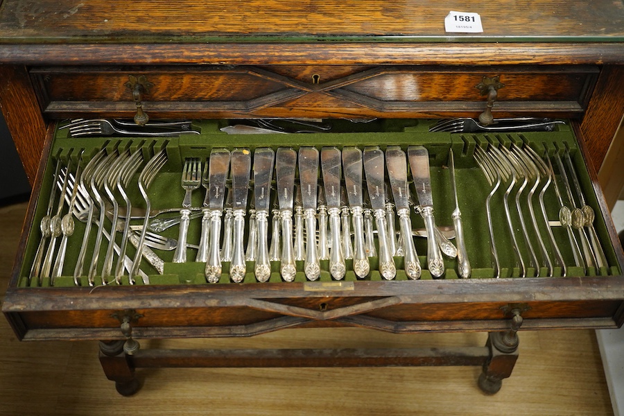 A 1920’s canteen of Old English pattern flatware, housed in a Queen Anne style oak cabinet, 87cm high